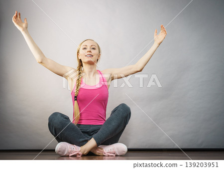 Woman in sportswear sitting on ground Woman in sportswear sitting on ground 139203951