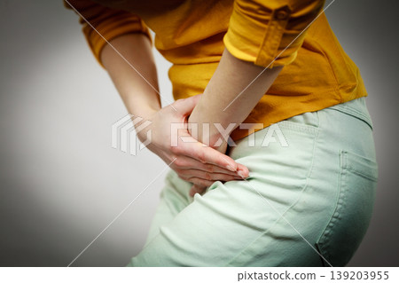 woman with hands holding her crotch 139203955