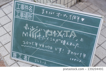 一塊手寫的黑板式告示牌，宣布商店成立一週年。 139204491