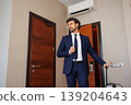 Stylish Business Man In Hotel Room Adjusting Tie After Arrival 139204643