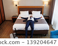 Business traveler lying on hotel bed relaxing after successful trip and long journey 139204647