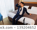 Fatigued Male Executive Resting in Hotel Room on Bed During Business Travel 139204652
