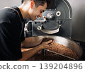 Smiling male worker checking roasted coffee beans at an industrial machine 139204896