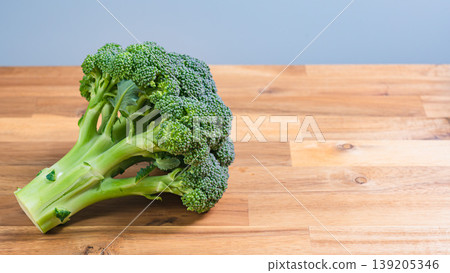 Fresh broccoli vegetables placed on a wooden table. 139205346