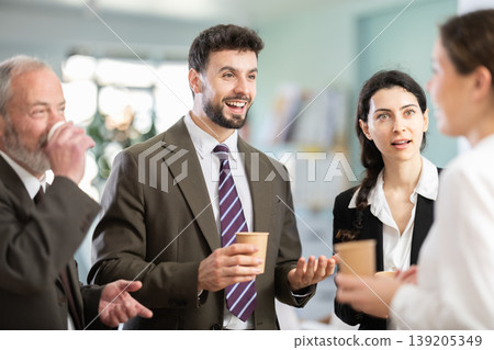 Multiage colleagues chat and laugh during coffee break Multiage colleagues chat and laugh during coffee break 139205349