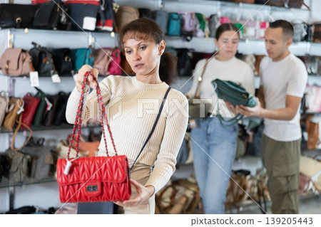 Adult woman choosing handbag in store Adult woman choosing handbag in store 139205443
