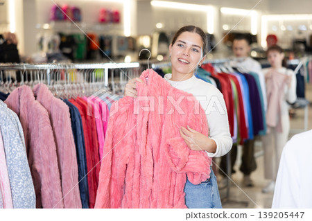 Young woman choosing bathrobe in store Young woman choosing bathrobe in store 139205447