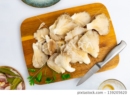 Preparing to cook soup or other dishes from fresh oyster mushrooms in kitchen Preparing to cook soup or other dishes from fresh oyster mushrooms in kitchen 139205620
