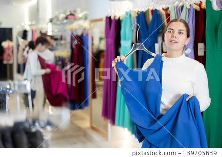 Young woman choosing dress in store 139205639