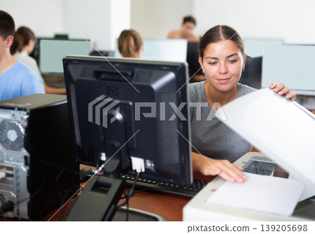Female teacher uses a scanner in computer lab at school 139205698