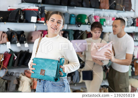 Young girl choosing handbag in clothing store Young girl choosing handbag in clothing store 139205819