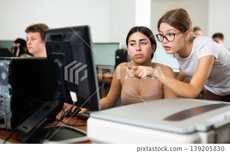 Teenage girls learning to use personal computer in school 139205830