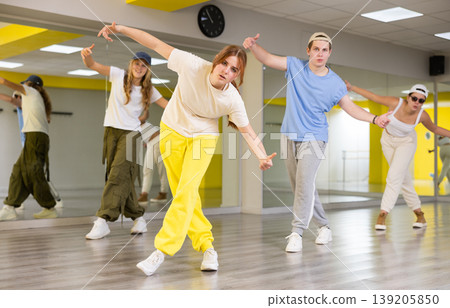 Expressive cool young dancers rehearsing their new dance during training together in studio 139205850