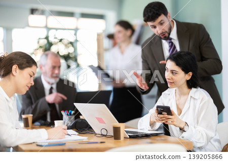 Man boss found girl subordinate idling and scrolling phone, mentor shouts at subordinate. 139205866