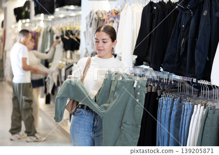 Young girl choosing casual pants in clothing store Young girl choosing casual pants in clothing store 139205871