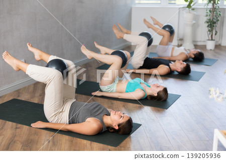 Young people doing softball pilates in studio. Young people doing softball pilates in studio. 139205936