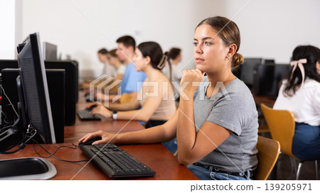Teacher works at computer in the classroom. Students doing programming 139205971