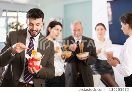 Male companys employees eat instant noodles, lunch time during break for staff Male companys employees eat instant noodles, lunch time during break for staff 139205983
