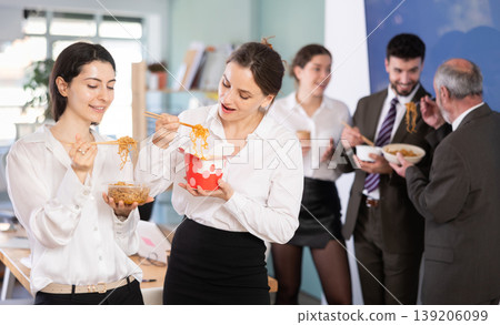 Office workers are eating noodles during their break and chatting with each other Office workers are eating noodles during their break and chatting with each other 139206099