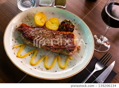 Beef entrecote served on plate with potatoes and mustard and glass of wine Beef entrecote served on plate with potatoes and mustard and glass of wine 139206134