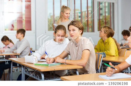 Teenage girls and boys exercising during lesson in school 139206198