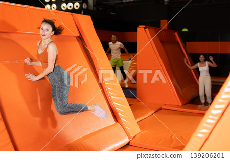 Emotional woman pushing off from angled surface in trampoline park Emotional woman pushing off from angled surface in trampoline park 139206201