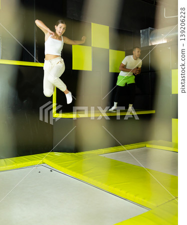 Excited young girl jumping at indoor trampoline center Excited young girl jumping at indoor trampoline center 139206228