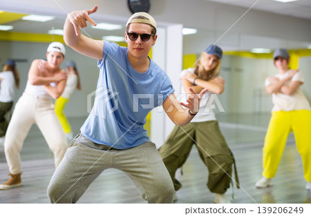 Emotional teen boy dancing with group of friends in dance studio. Hip hop generation 139206249