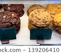 Chocolate cookies stack and bakery biscuits in showcase. Sweet snack, dessert selection, sugar intake, baked goods display, and confectionery assortment in cafe environment. 139206410