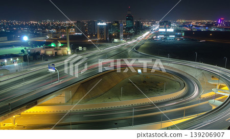 Traffic on a big road junction in Ajman aerial view from rooftop at night timelapse. 139206907