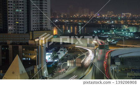 Traffic on a big road junction in Ajman aerial view from rooftop at night timelapse. 139206908