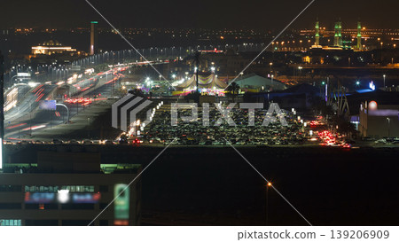 Traffic on a big parking lot in Ajman aerial view from rooftop at night timelapse. 139206909