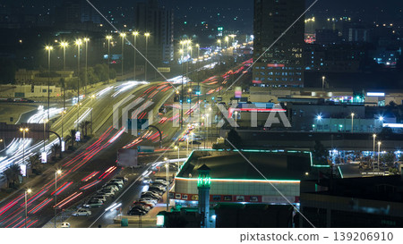 Traffic on a big road junction in Ajman aerial view from rooftop at night timelapse. 139206910