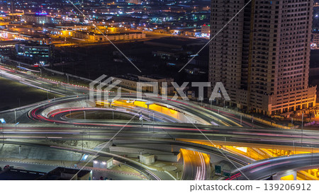 Traffic on a big road junction in Ajman aerial view from rooftop at night timelapse. 139206912