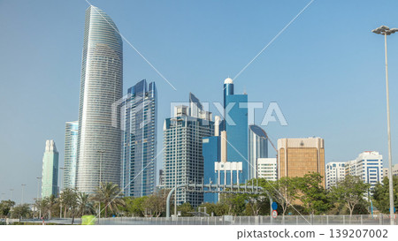 Corniche boulevard beach park along the coastline in Abu Dhabi timelapse with skyscrapers on background. 139207002