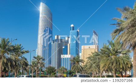 Corniche boulevard beach park along the coastline in Abu Dhabi timelapse with skyscrapers on background. Corniche boulevard beach park along the coastline in Abu Dhabi timelapse with skyscrapers on background. 139207166