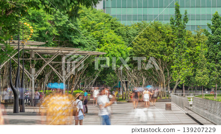Walk way with trees beside at parks and outdoor of marina bay with Singapore skyscrapers skyline timelapse Walk way with trees beside at parks and outdoor of marina bay with Singapore skyscrapers skyline timelapse 139207229