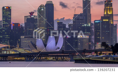 Downtown skyline of Singapore as viewed from across the water from The Garden East day to night timelapse. Singapore. Downtown skyline of Singapore as viewed from across the water from The Garden East day to night timelapse. Singapore. 139207231