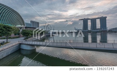 Skyline in Marina Bay with Esplanade Theaters on the Bay and Esplanade footbridge night to day timelapse in Singapore. Skyline in Marina Bay with Esplanade Theaters on the Bay and Esplanade footbridge night to day timelapse in Singapore. 139207243