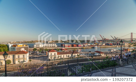 Skyline over Lisbon commercial port timelapse, 25th April Bridge, containers on pier with freight cranes 139207372