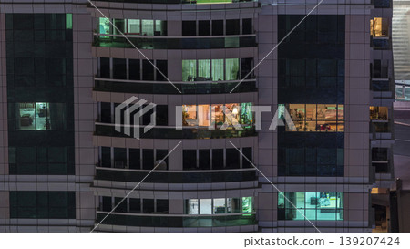 Night view of exterior apartment building timelapse. High rise skyscraper with blinking lights in windows Night view of exterior apartment building timelapse. High rise skyscraper with blinking lights in windows 139207424