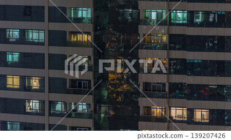 Night view of exterior apartment building timelapse. High rise skyscraper with blinking lights in windows Night view of exterior apartment building timelapse. High rise skyscraper with blinking lights in windows 139207426