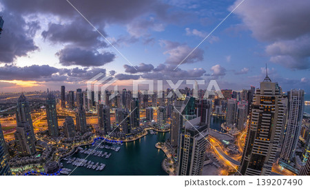 Dubai Marina skyscrapers and jumeirah lake towers view from the top aerial night to day timelapse in the United Arab Emirates. Dubai Marina skyscrapers and jumeirah lake towers view from the top aerial night to day timelapse in the United Arab Emirates. 139207490