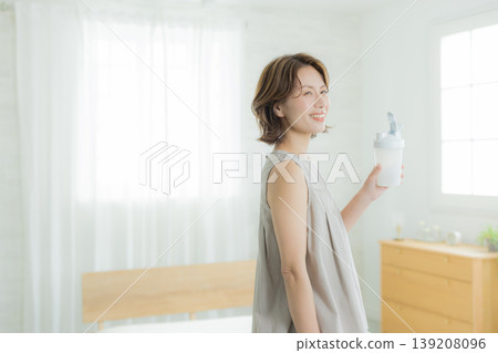  Woman drinking protein 139208096