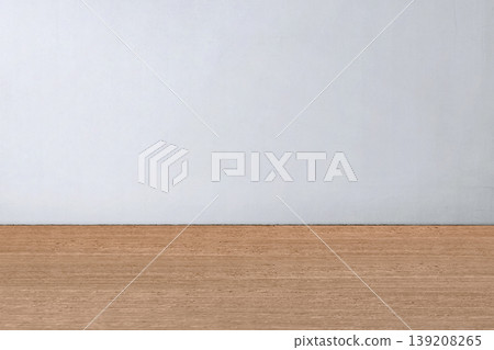 A clean and minimalist empty room featuring a smooth wooden floor and a plain light grey wall, perfect for product mockups and interior design presentations A clean and minimalist empty room featuring a smooth wooden floor and a plain light grey wall, perfect for product mockups and interior design presentations 139208265