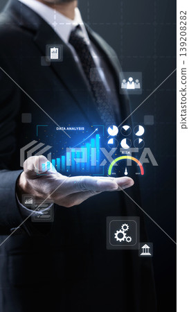 A businessman in a dark suit presents a futuristic virtual interface displaying data analysis, growing bar charts, risk indicators, and financial icons against a dark background A businessman in a dark suit presents a futuristic virtual interface displaying data analysis, growing bar charts, risk indicators, and financial icons against a dark background 139208282