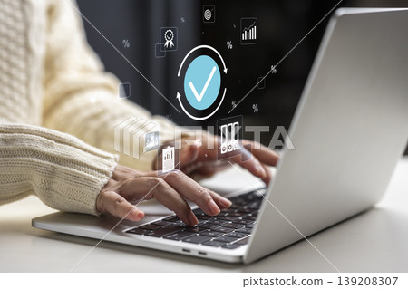 Person working on a laptop with digital icons representing quality assurance, verification, data analysis, and process standardization for business compliance Person working on a laptop with digital icons representing quality assurance, verification, data analysis, and process standardization for business compliance 139208307