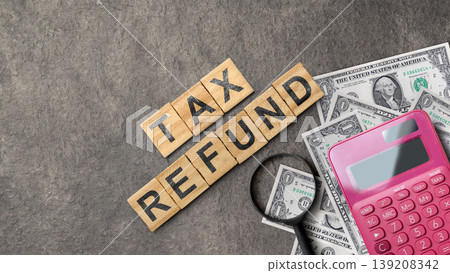 Top view of wooden blocks spelling TAX REFUND with US dollar bills, pink calculator, and magnifying glass on a grey background. Perfect for financial, accounting, and tax-related concepts Top view of wooden blocks spelling TAX REFUND with US dollar bills, pink calculator, and magnifying glass on a grey background. Perfect for financial, accounting, and tax-related concepts 139208342