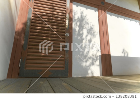 這是一個寧靜的建築空間，陽光透過木地板和百葉門灑進來。 139208381