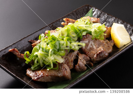 Bite-sized grilled beef tongue with green onions and salt. 139208586